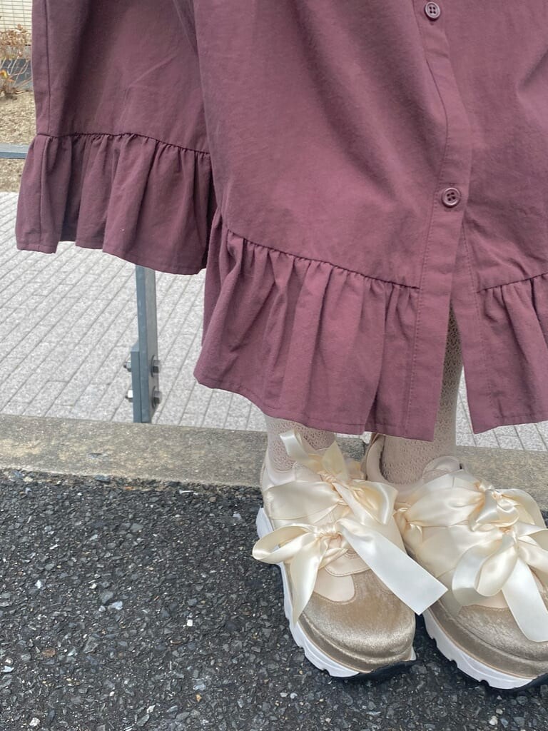 ホワイト系のナイロンジャケット、ホワイト系のショルダーバッグ、レッド系のワンピースを着用したレディースの冬コーディネートの4枚目の写真