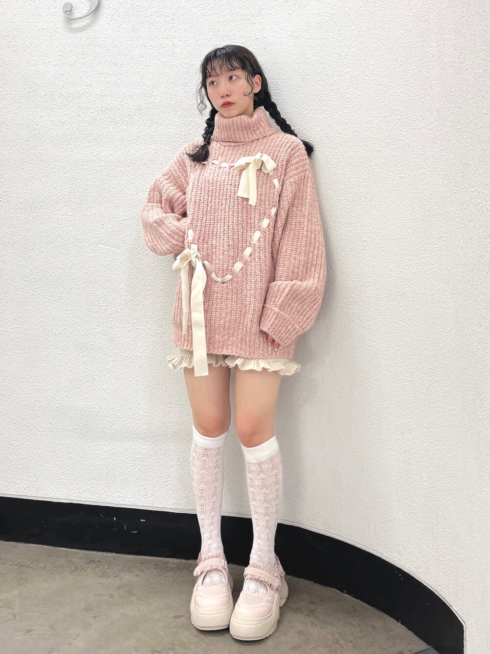 ピンク系のニット/セーター、ホワイト系のスウェットパンツ、ピンク系のスニーカーを着用したレディースの秋コーディネートの2枚目の写真