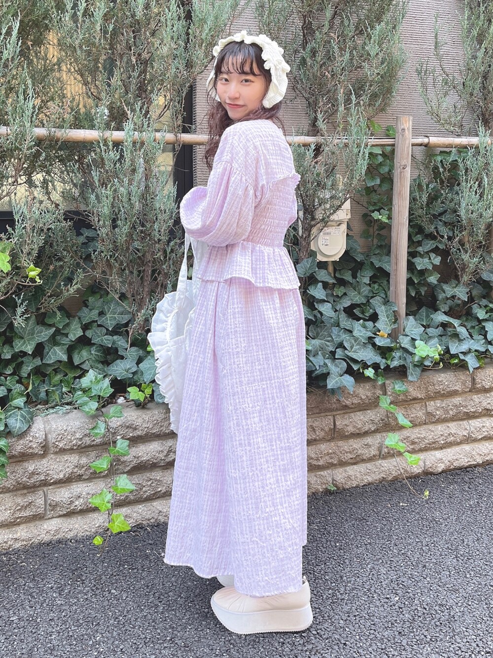 パープル系のワンピース、ホワイト系のトートバッグ、ホワイト系のバレエシューズを着用したレディースの冬コーディネートの3枚目の写真