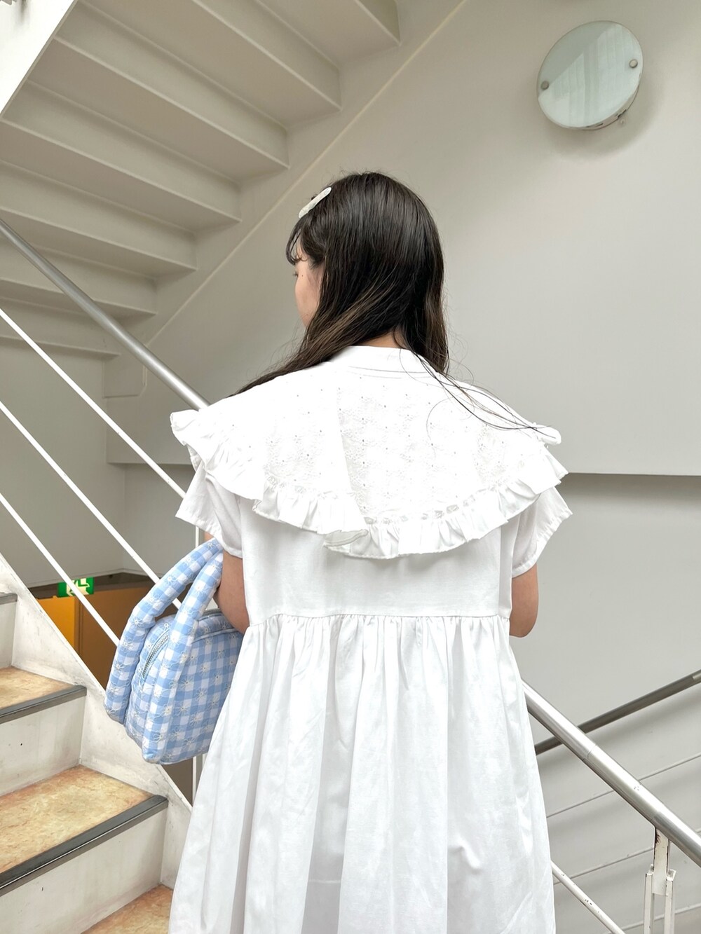 ホワイト系のワンピース、ブルー系のハンドバッグ、ピンク系のサンダルを着用したレディースの夏コーディネートの4枚目の写真