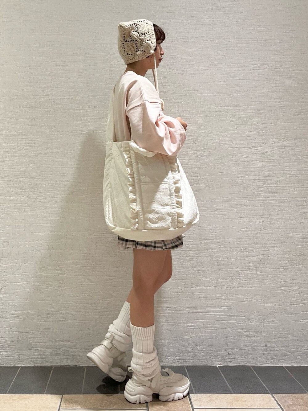 ピンク系のスウェット、ベージュ系のスカート、ホワイト系のトートバッグを着用したレディースの秋コーディネートの2枚目の写真