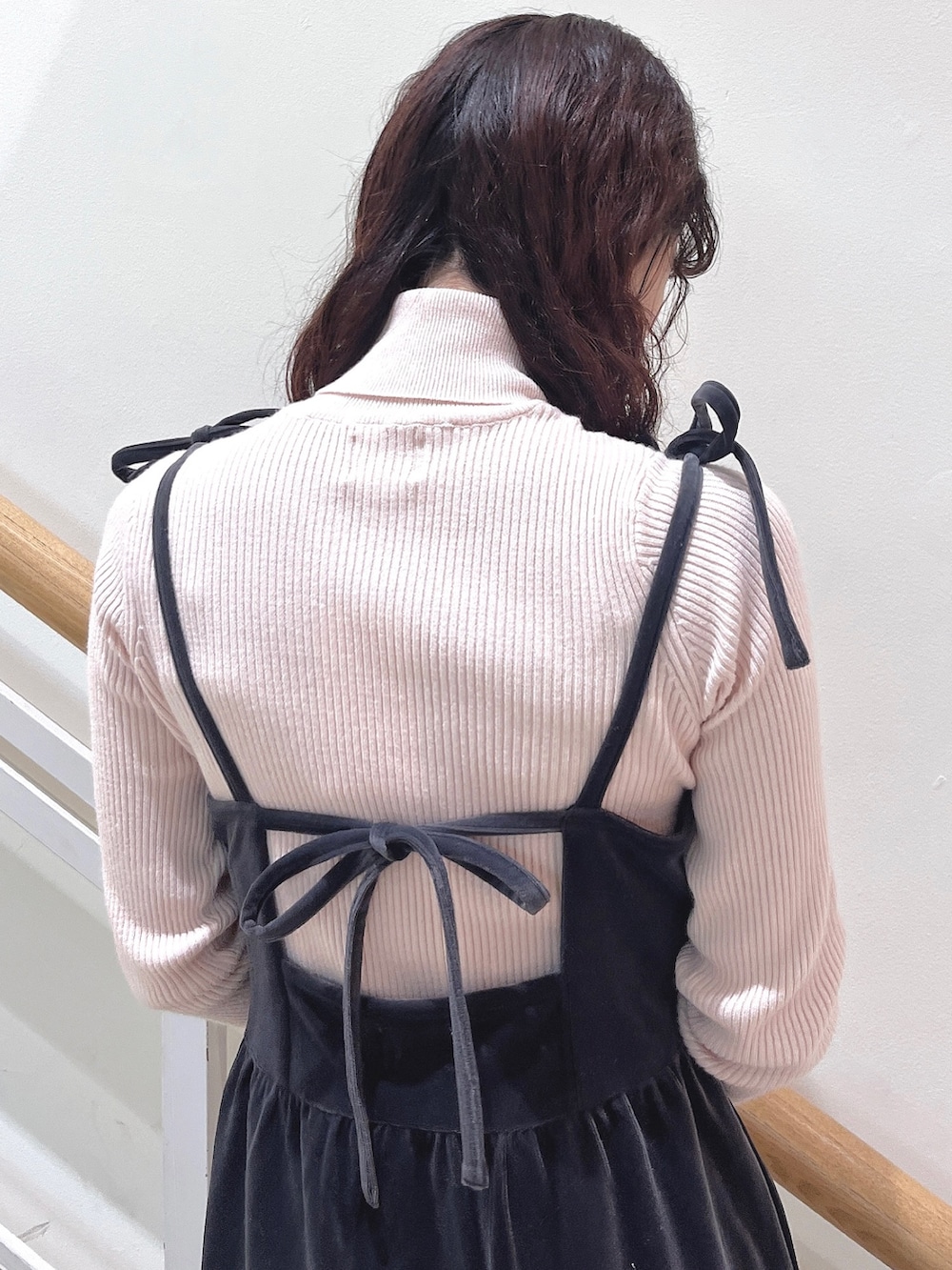 ピンク系のニット/セーター、グレー系のワンピース、ホワイト系のパンプスを着用したレディースの冬コーディネートの6枚目の写真