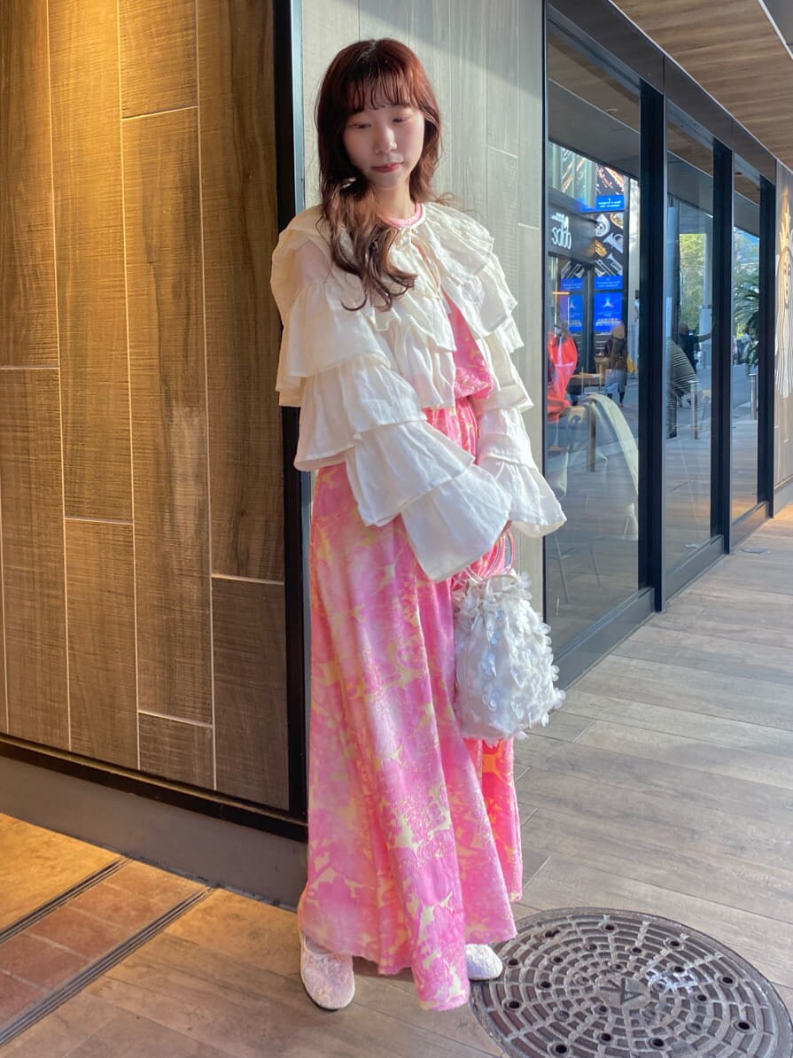 ピンク系のワンピース、ホワイト系のカーディガン/ボレロ、ホワイト系のパンプスを着用したレディースの冬コーディネートの2枚目の写真