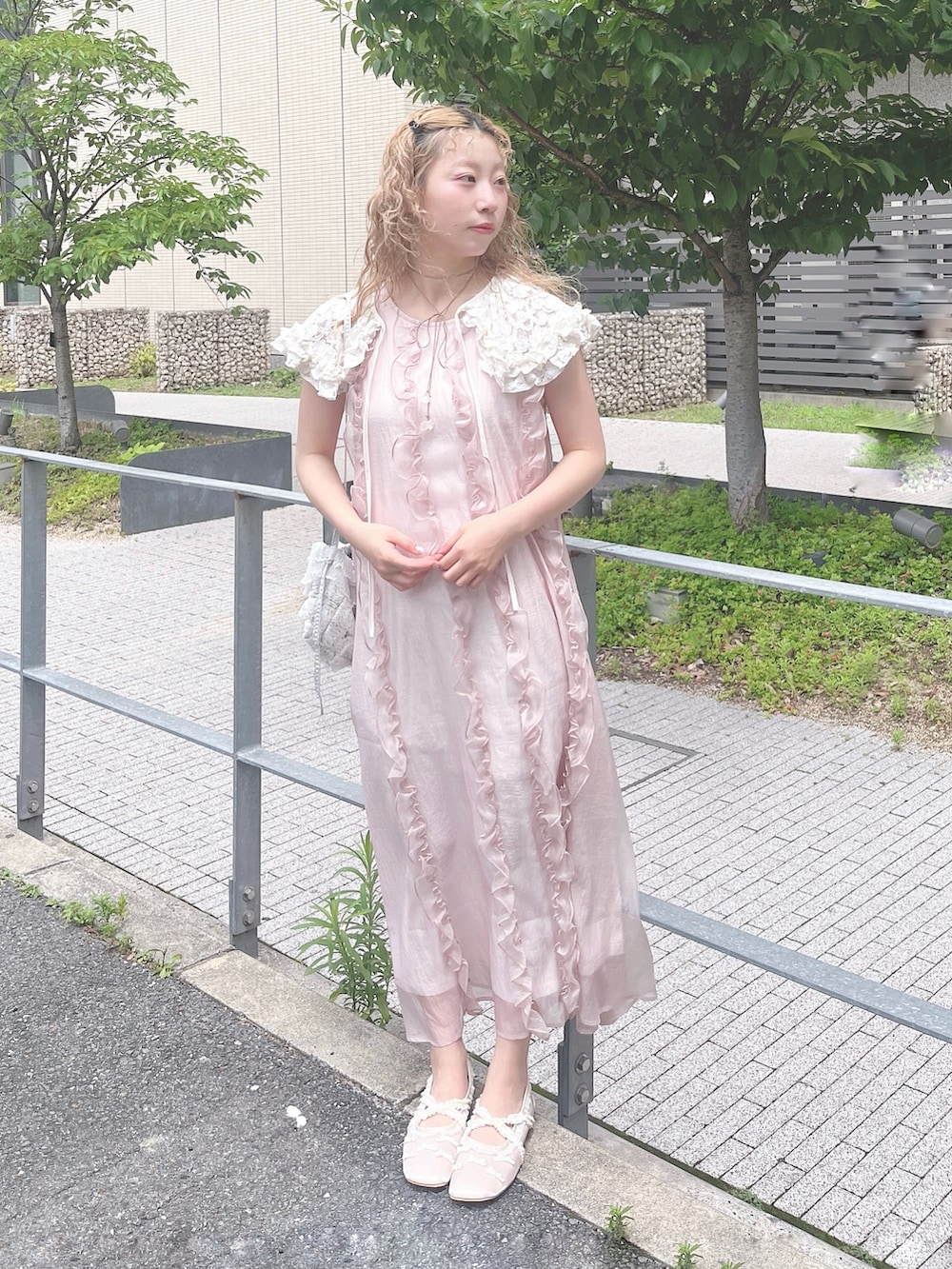 ピンク系のワンピース、ホワイト系のバレエシューズ、ブルー系のショルダーバッグを着用したレディースの夏コーディネートの2枚目の写真
