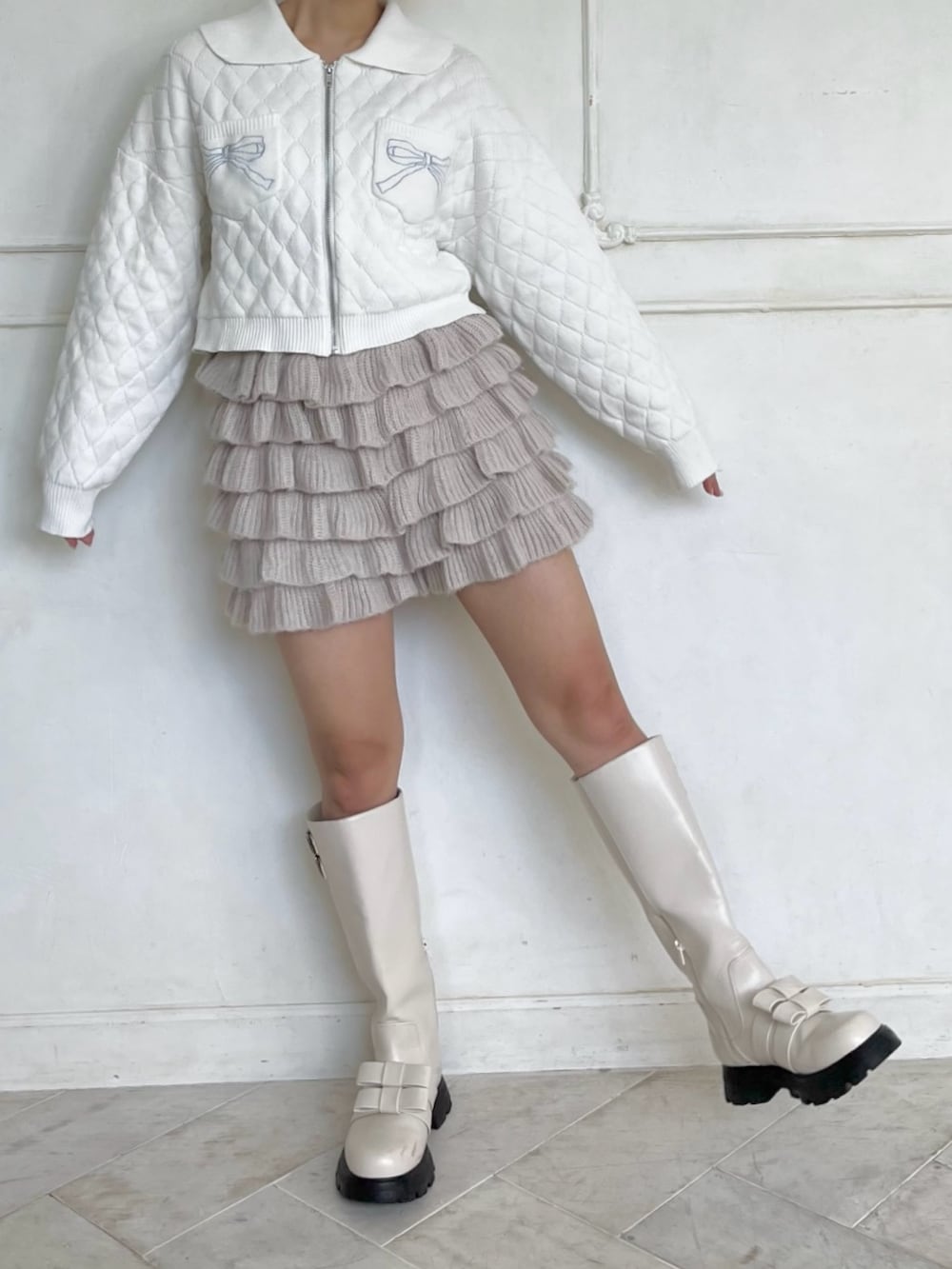 ホワイト系のカーディガン/ボレロ、ベージュ系のスウェットパンツ、ホワイト系のブーツを着用したレディースの秋コーディネートの5枚目の写真