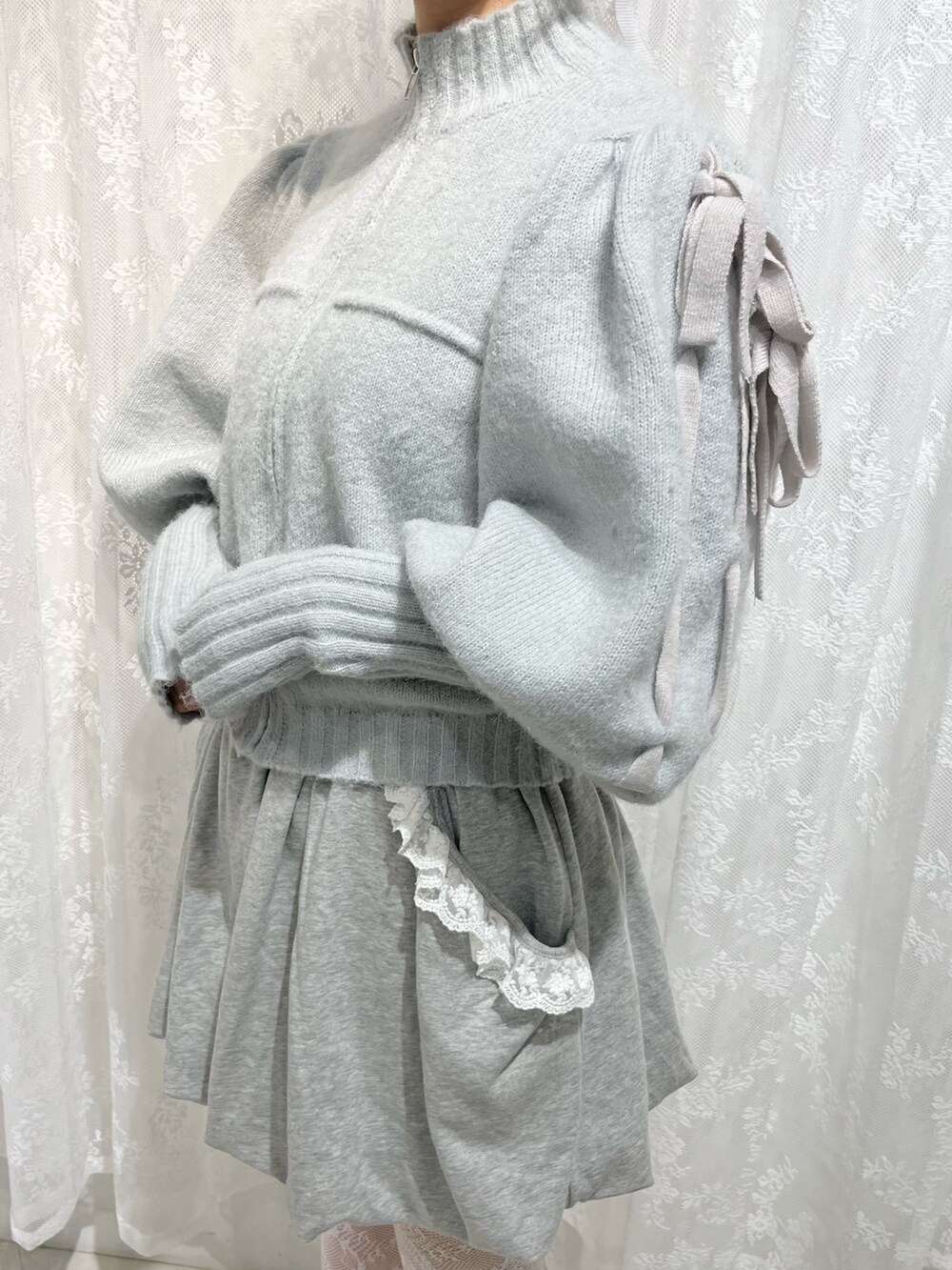 グリーン系のカーディガン/ボレロ、グレー系のスカート、ホワイト系のスニーカーを着用したレディースの秋コーディネートの5枚目の写真