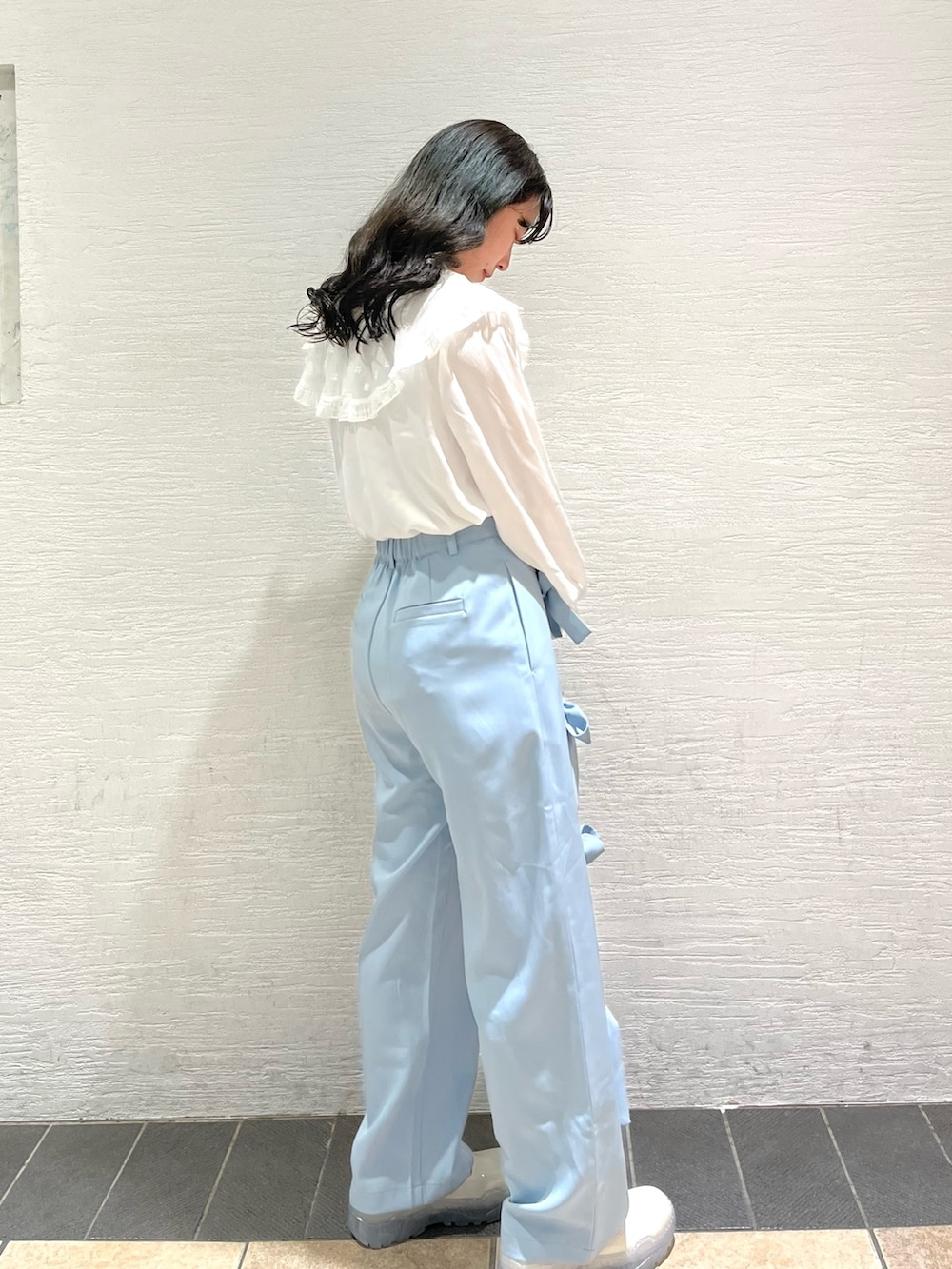 ホワイト系のチュニック、ブルー系のその他パンツ、ホワイト系のスニーカーを着用したレディースの春コーディネートの2枚目の写真