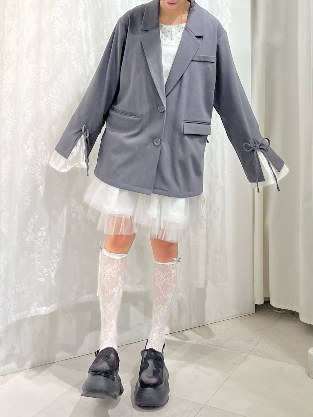 グレー系のテーラードジャケット、ブルー系のTシャツ/カットソー、ホワイト系のワンピースを着用したレディースの冬コーディネートの5枚目の写真