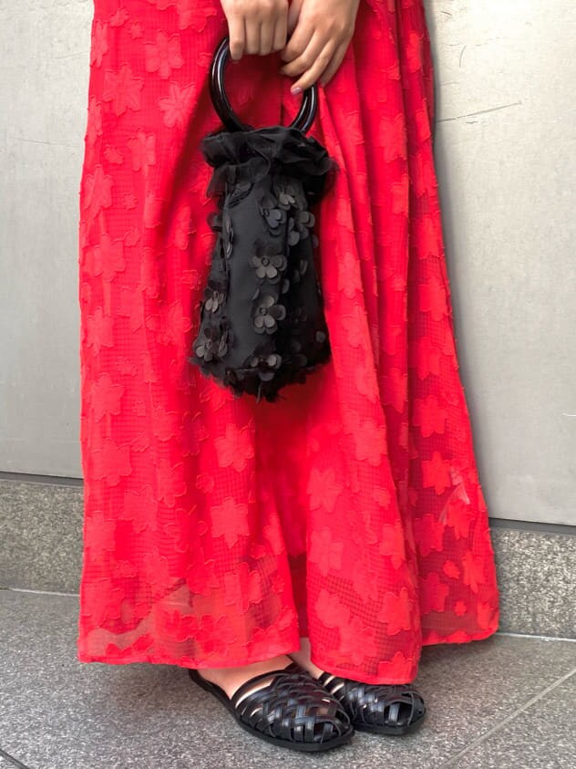 ブラック系のハンドバッグ、レッド系のワンピース、ブラック系のパンプスを着用したレディースの春コーディネートの6枚目の写真