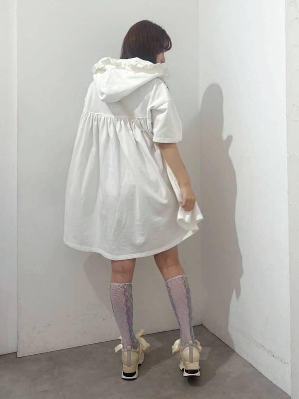 ホワイト系のスニーカー、ピンク系のショルダーバッグ、ホワイト系のワンピースを着用したレディースの春コーディネートの2枚目の写真