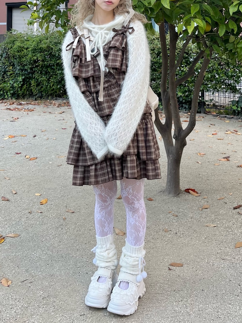 ホワイト系のニット/セーター、ブラウン系のワンピース、ベージュ系のショルダーバッグを着用したレディースの秋コーディネートの4枚目の写真