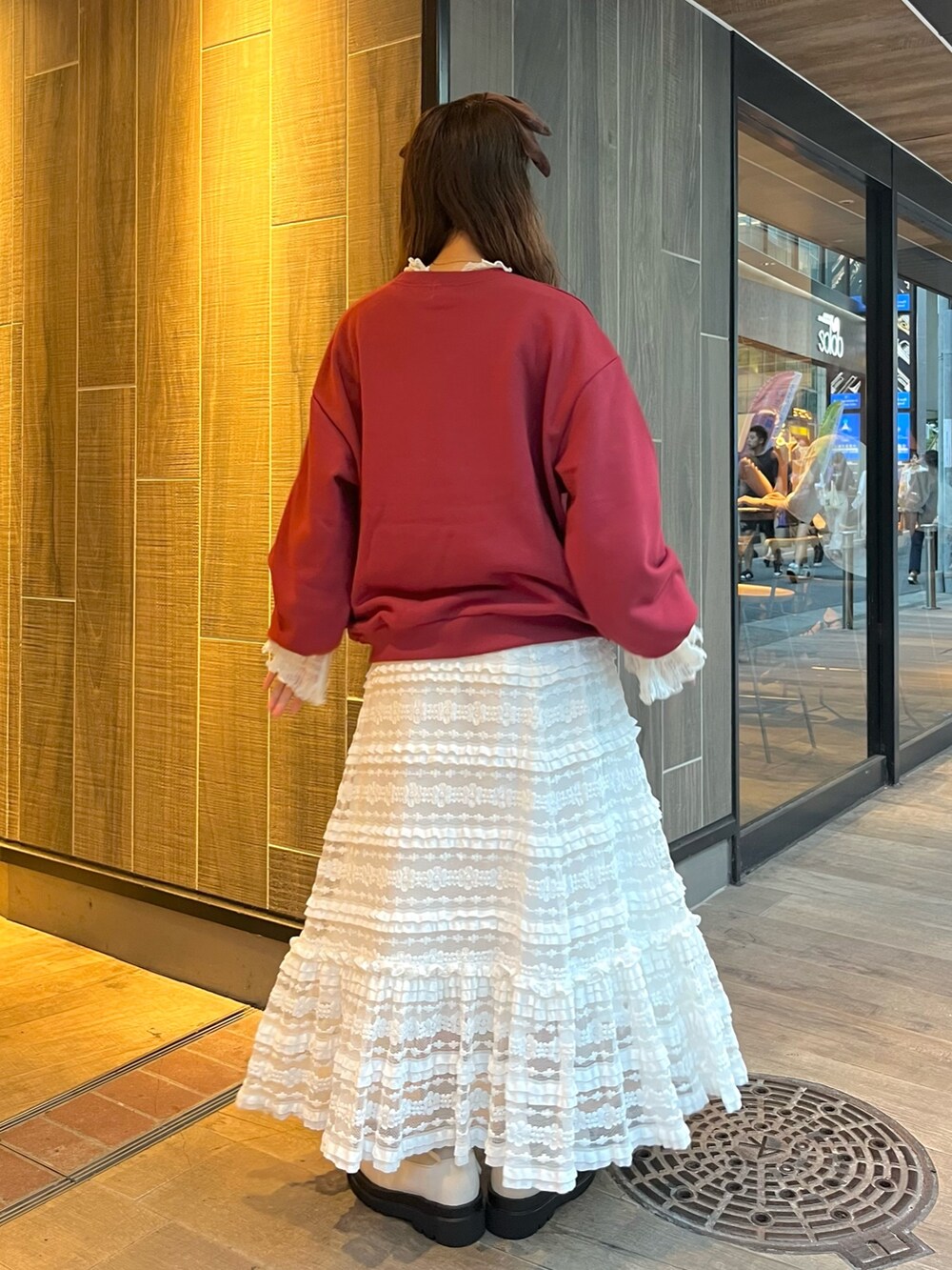 レッド系のスウェット、ホワイト系のTシャツ/カットソー、ホワイト系のスカートを着用したレディースの秋コーディネートの3枚目の写真