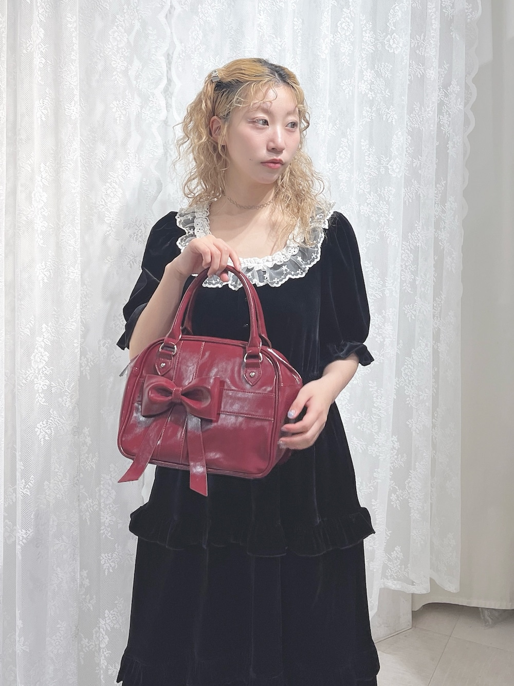 ブラック系のワンピース、レッド系のハンドバッグ、ブラック系のパンプスを着用したレディースの夏コーディネートの4枚目の写真