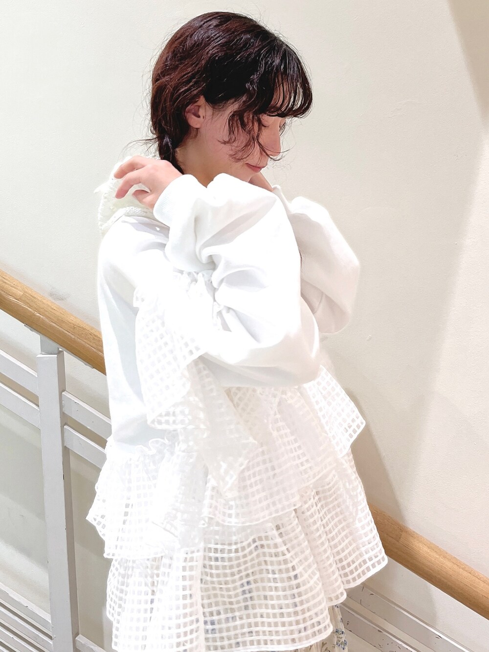 ホワイト系のスウェット、ブルー系のスカート、ホワイト系のスニーカーを着用したレディースの冬コーディネートの7枚目の写真