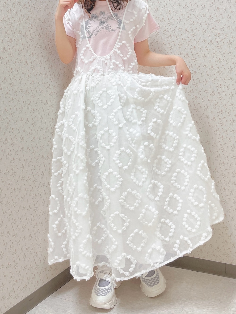 ピンク系のTシャツ/カットソー、ホワイト系のジャンパースカート、ホワイト系のスニーカーを着用したレディースの夏コーディネートの6枚目の写真