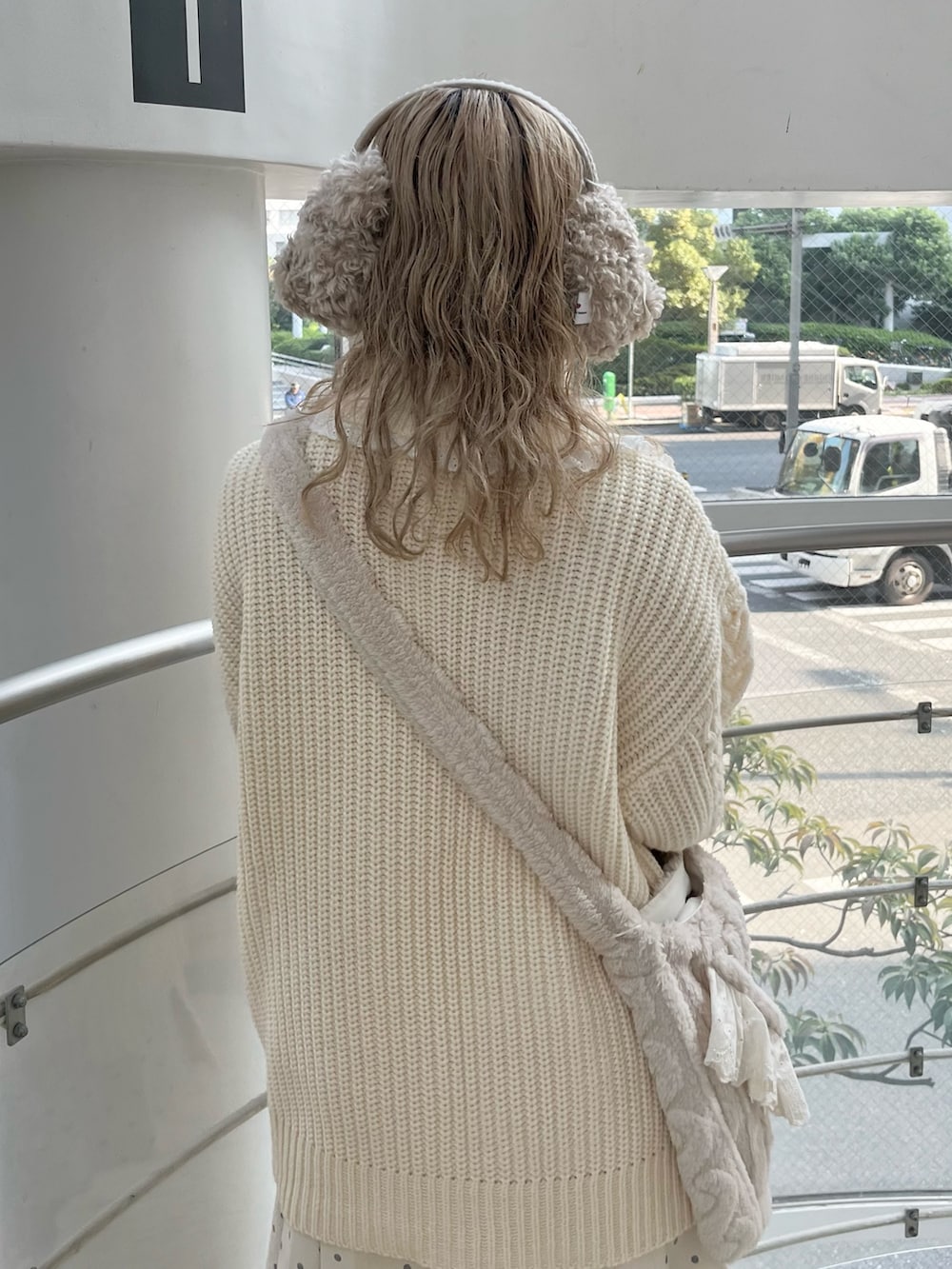 ホワイト系のカーディガン/ボレロ、ホワイト系のスカート、ベージュ系のショルダーバッグを着用したレディースの冬コーディネートの6枚目の写真