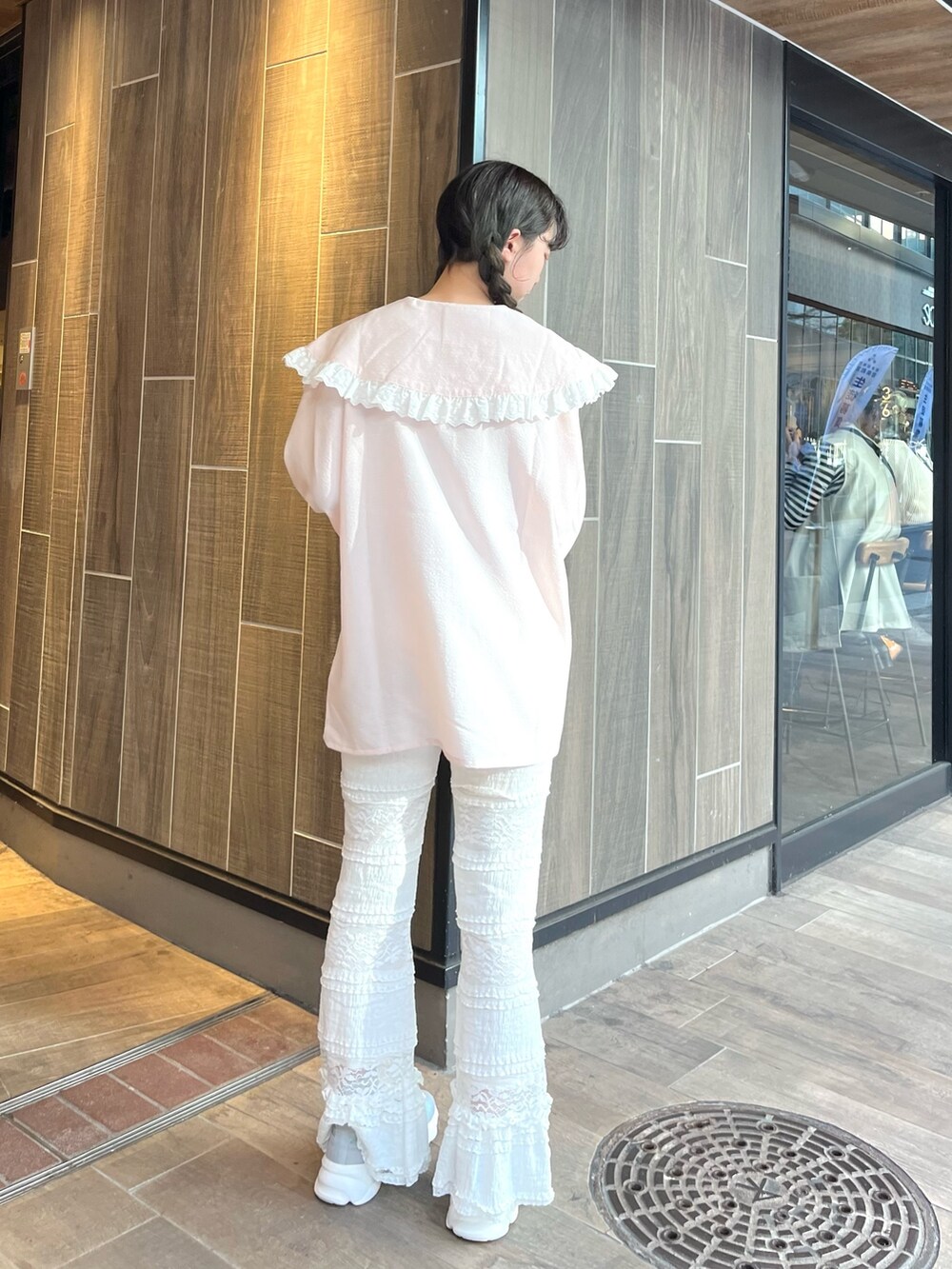 ピンク系のシャツ/ブラウス、ホワイト系のスラックス、ブルー系のスニーカーを着用したレディースの春コーディネートの3枚目の写真