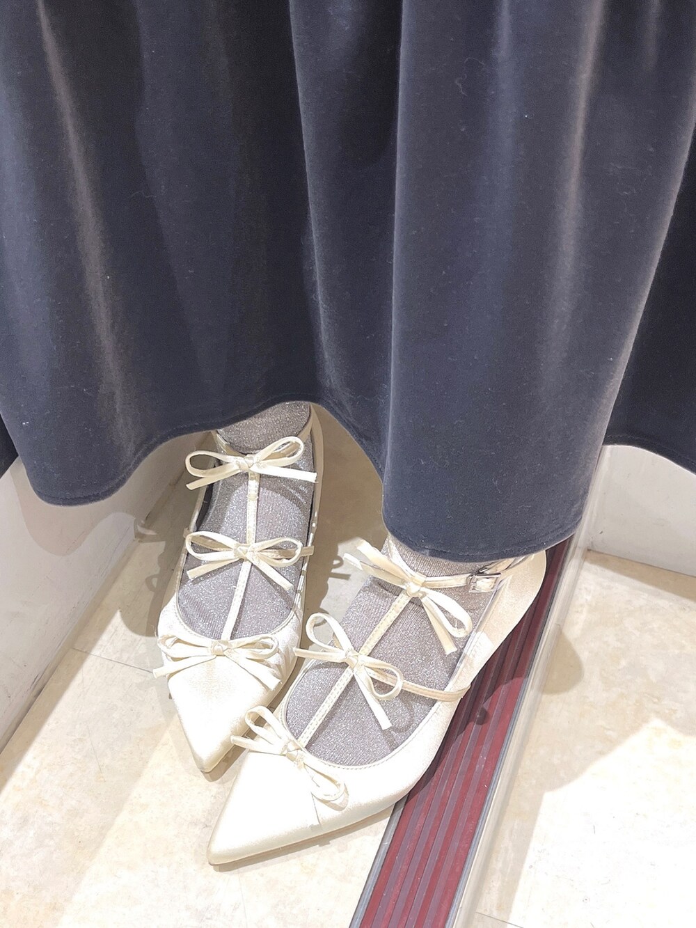 ピンク系のニット/セーター、グレー系のワンピース、ホワイト系のパンプスを着用したレディースの冬コーディネートの10枚目の写真