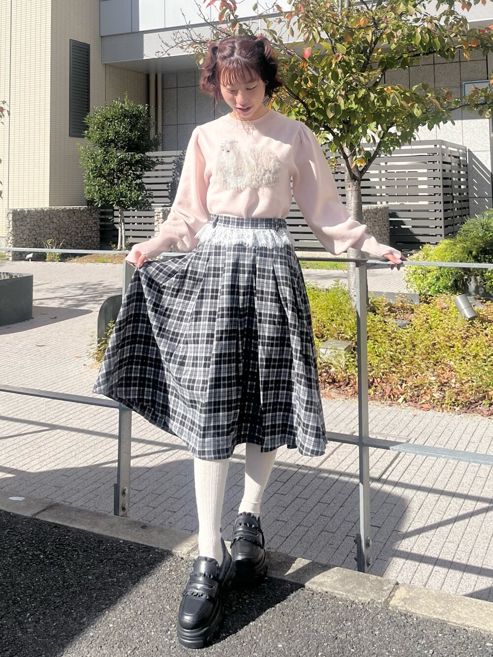 ピンク系のニット/セーター、ブラック系のスカート、ブラック系のローファーを着用したレディースの冬コーディネートの8枚目の写真