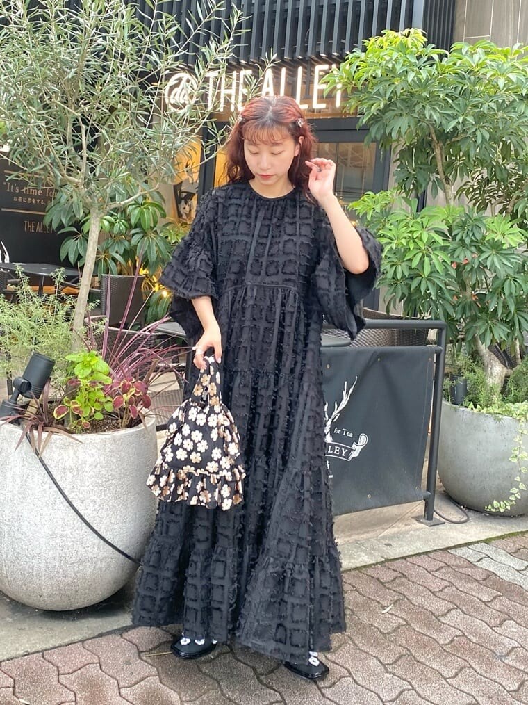 ブラック系のワンピース、ブラック系のパンプス、その他のハンドバッグを着用したレディースの秋コーディネートの3枚目の写真