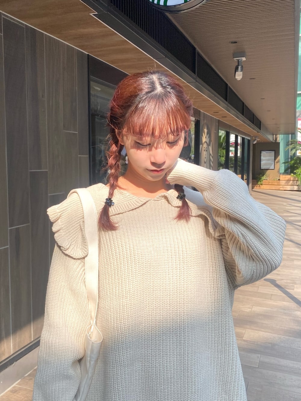 ホワイト系のニット/セーター、ホワイト系のトートバッグ、ブルー系のスカートを着用したレディースの冬コーディネートの4枚目の写真