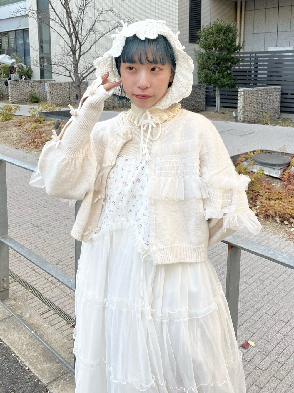 ホワイト系のニット/セーター、ホワイト系のカーディガン/ボレロ、ホワイト系のワンピースを着用したレディースの冬コーディネートの5枚目の写真
