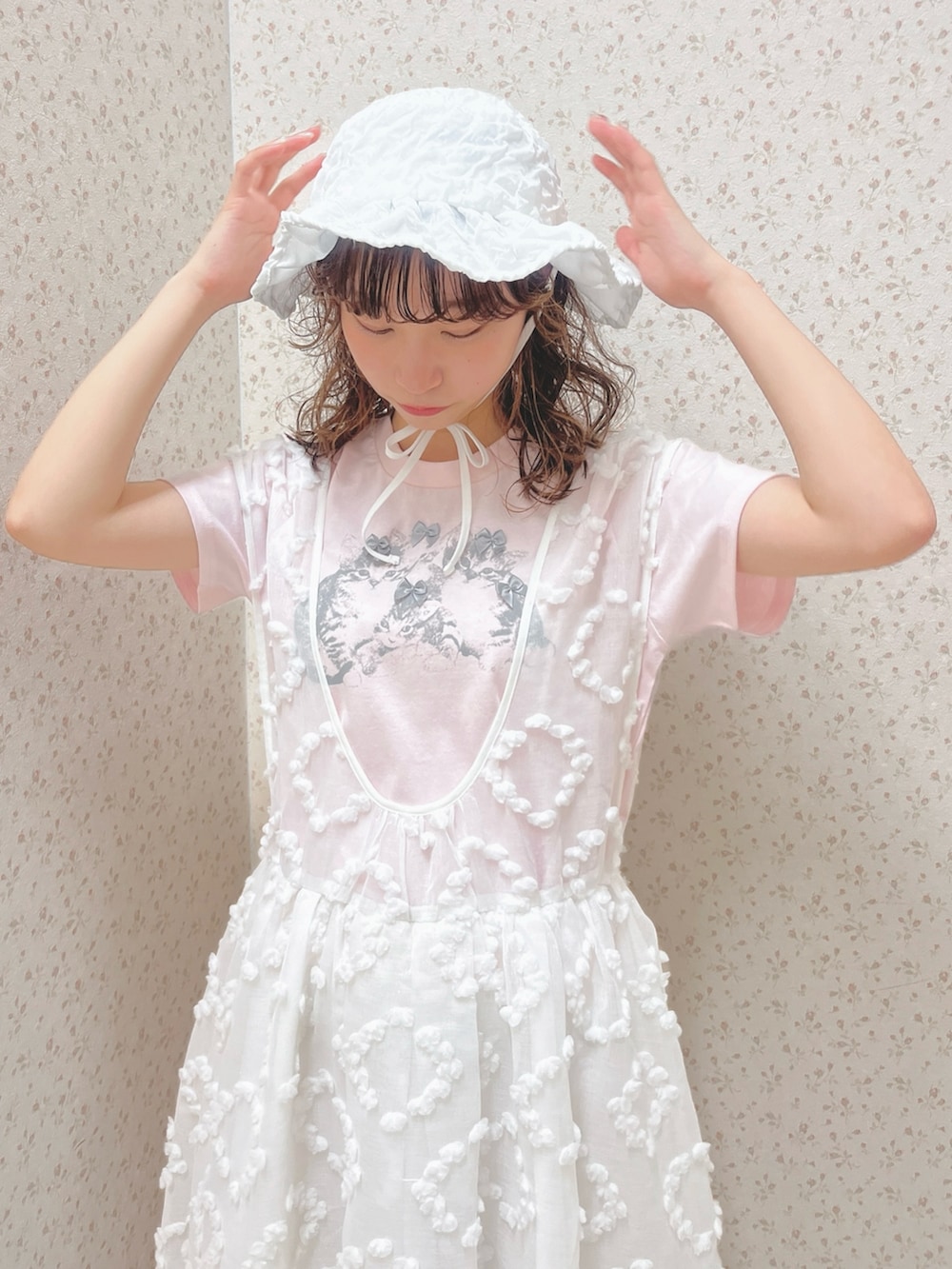 ピンク系のTシャツ/カットソー、ホワイト系のジャンパースカート、ホワイト系のスニーカーを着用したレディースの夏コーディネートの7枚目の写真