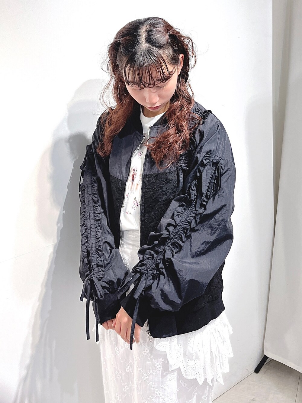 ブラック系のブルゾン、ホワイト系のTシャツ/カットソー、ホワイト系のスカートを着用したレディースの冬コーディネートの4枚目の写真