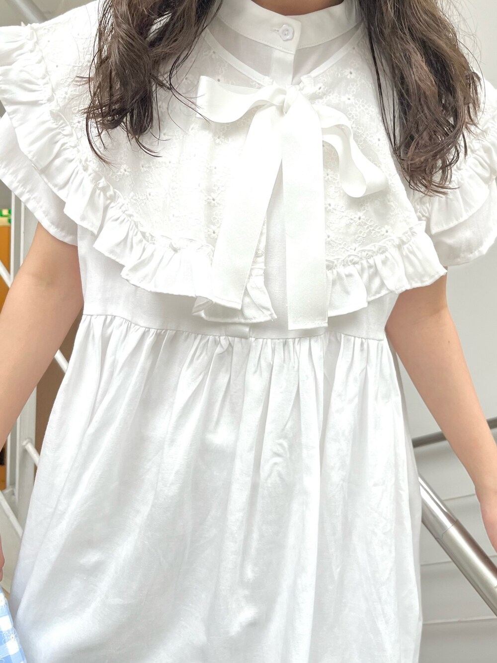 ホワイト系のワンピース、ブルー系のハンドバッグ、ピンク系のサンダルを着用したレディースの夏コーディネートの5枚目の写真