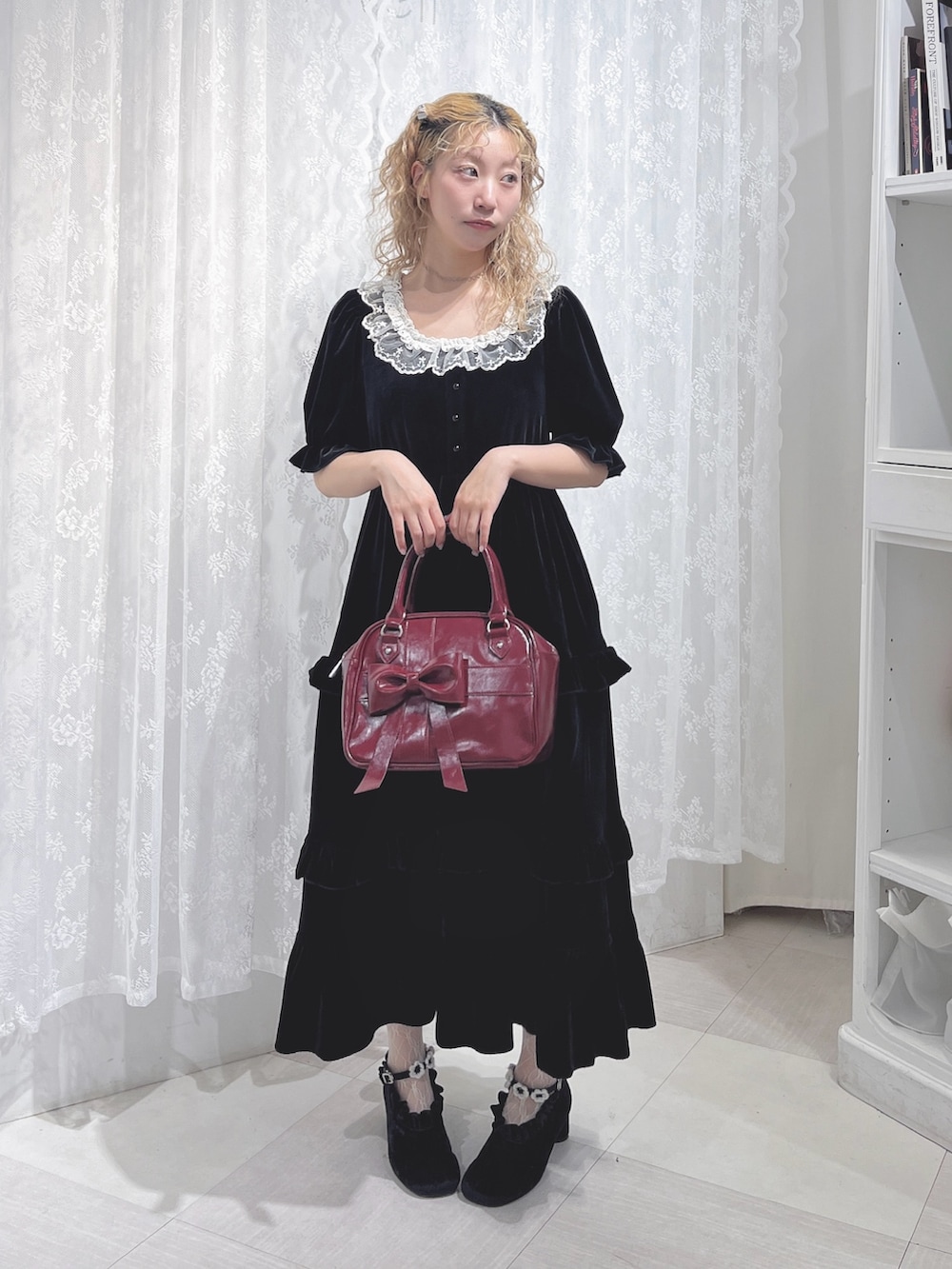 ブラック系のワンピース、レッド系のハンドバッグ、ブラック系のパンプスを着用したレディースの夏コーディネートの2枚目の写真