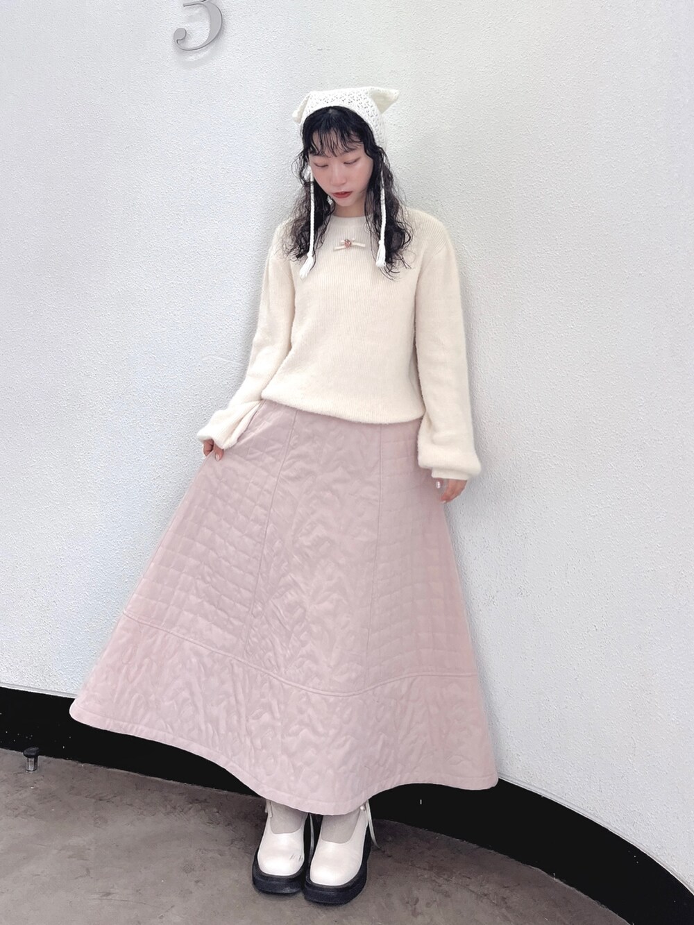 ホワイト系のニット/セーター、ピンク系のスカート、ホワイト系のブーツを着用したレディースの秋コーディネートの3枚目の写真