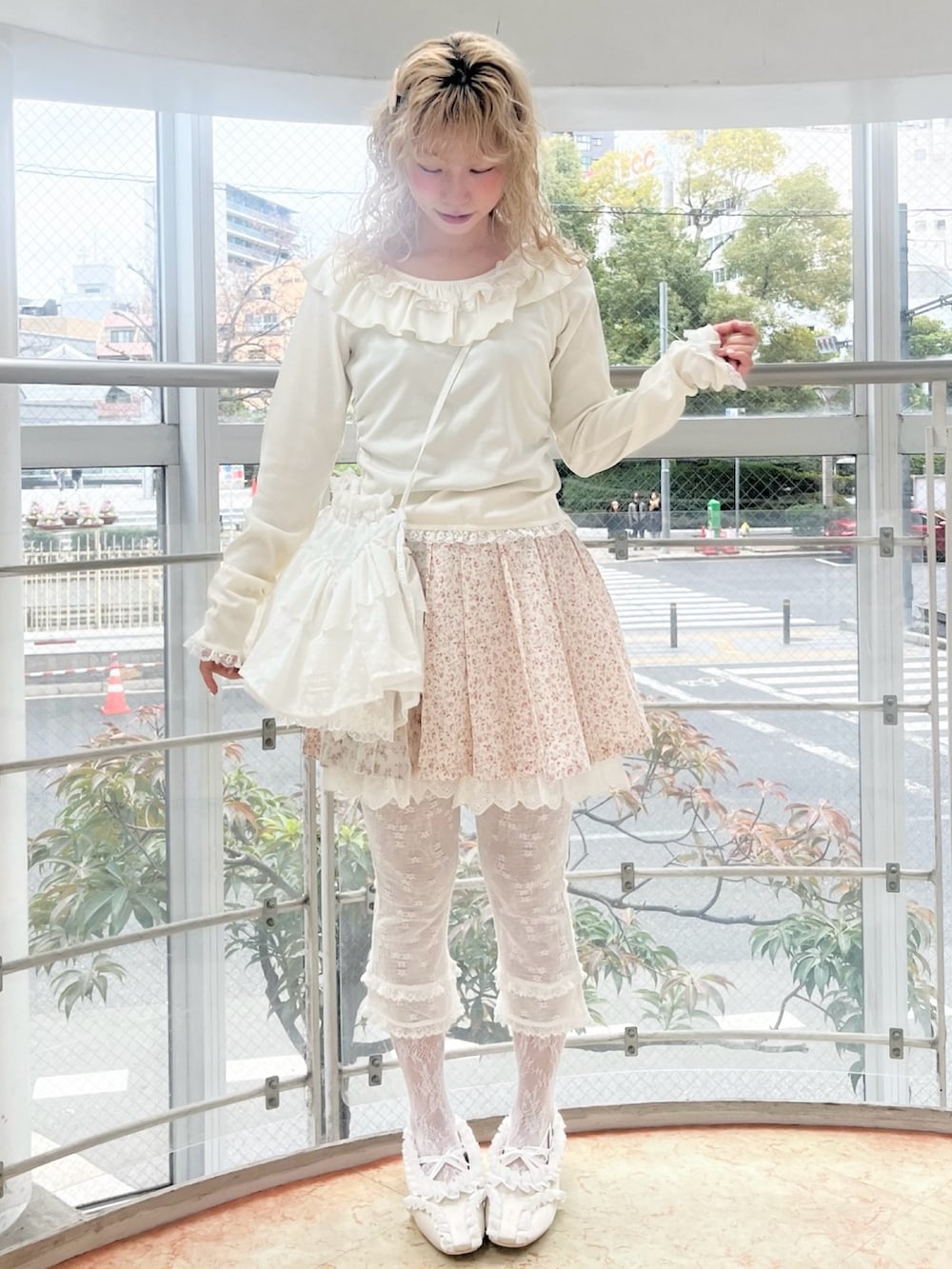 ホワイト系のTシャツ/カットソー、ホワイト系のショルダーバッグ、ピンク系のスカートを着用したレディースの冬コーディネートの2枚目の写真