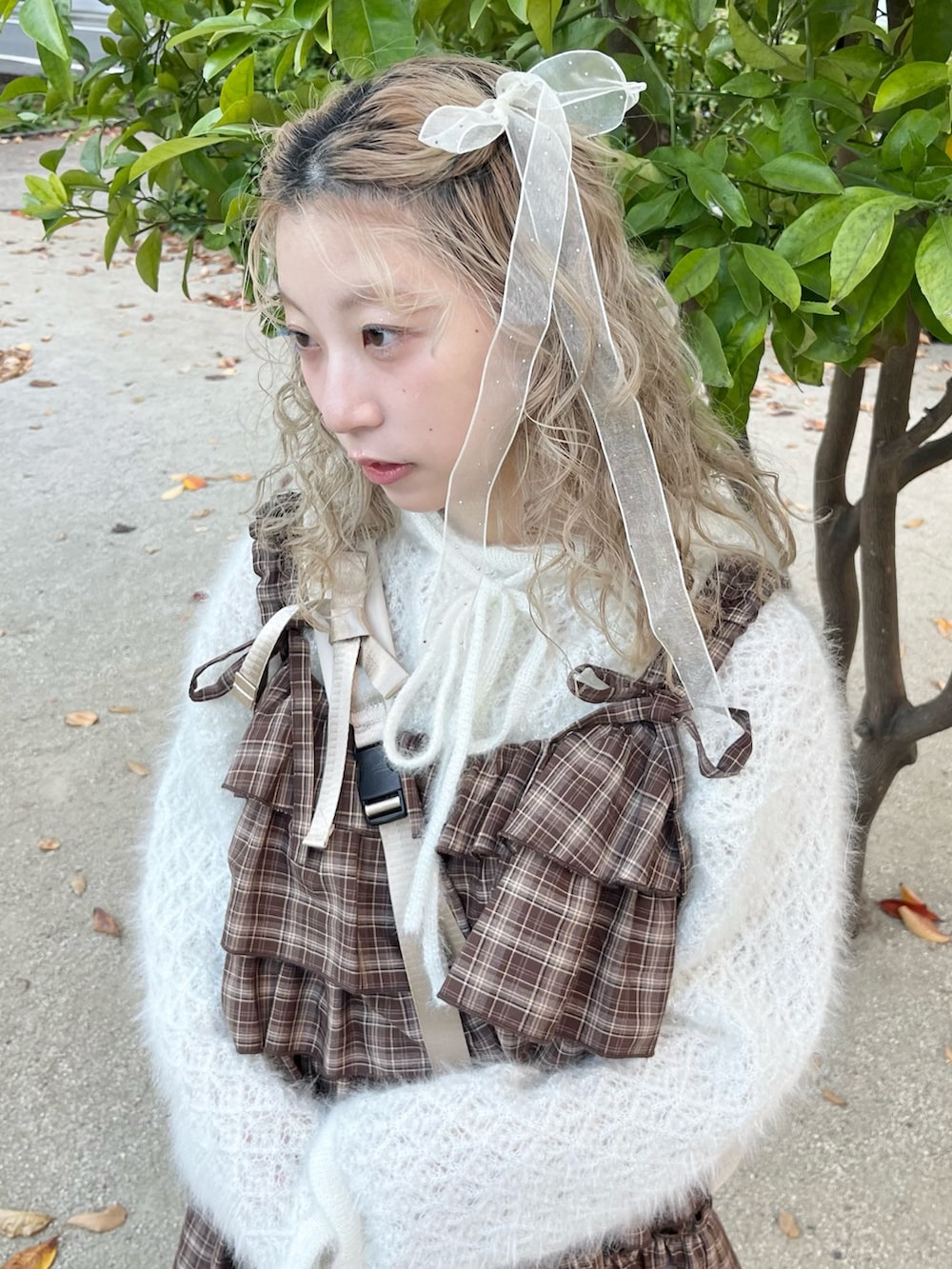 ホワイト系のニット/セーター、ブラウン系のワンピース、ベージュ系のショルダーバッグを着用したレディースの秋コーディネートの6枚目の写真