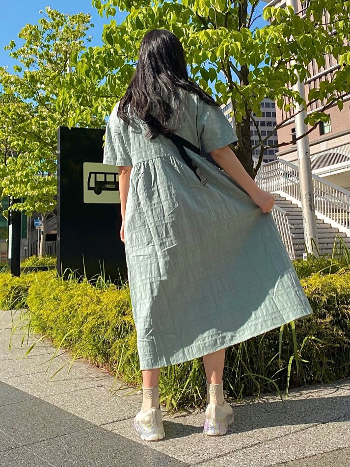 ホワイト系のボディバッグ/ウエストポーチ、グリーン系のワンピース、ホワイト系のスニーカーを着用したレディースの春コーディネートの3枚目の写真