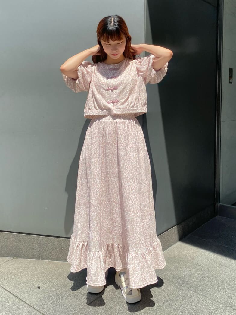 ピンク系のシャツ/ブラウス、ピンク系のスカート、ホワイト系のサンダルを着用したレディースの春コーディネートの2枚目の写真