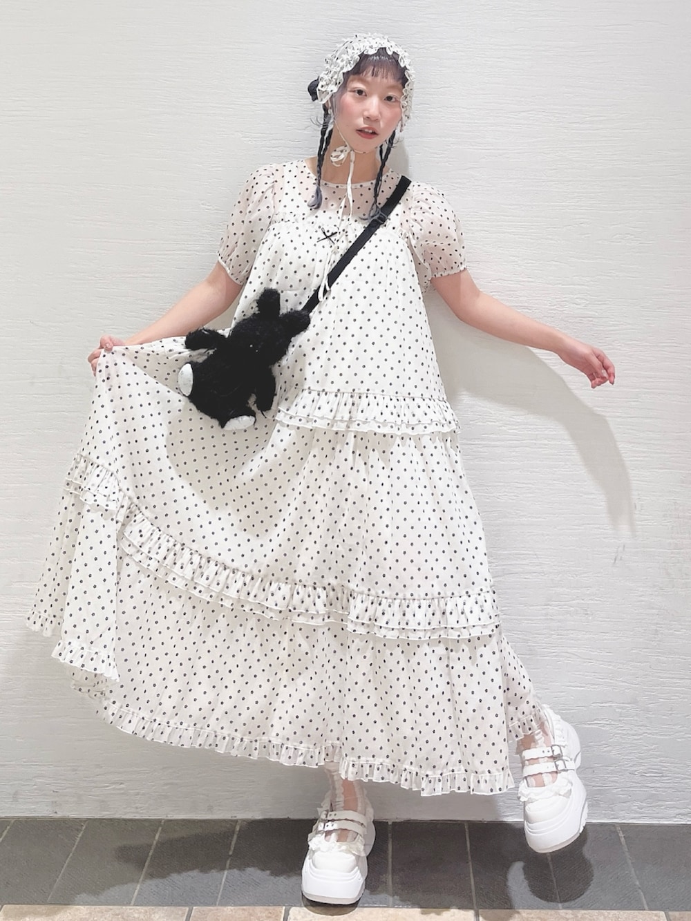 ホワイト系のワンピース、ブラック系のショルダーバッグ、ホワイト系のスニーカーを着用したレディースの春コーディネートの3枚目の写真