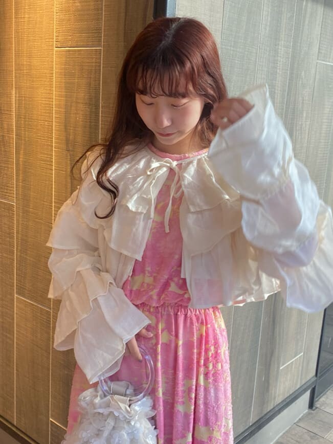 ピンク系のワンピース、ホワイト系のカーディガン/ボレロ、ホワイト系のパンプスを着用したレディースの冬コーディネートの4枚目の写真