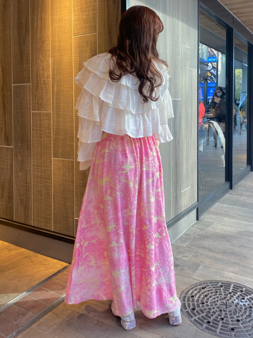 ピンク系のワンピース、ホワイト系のカーディガン/ボレロ、ホワイト系のパンプスを着用したレディースの冬コーディネートの3枚目の写真