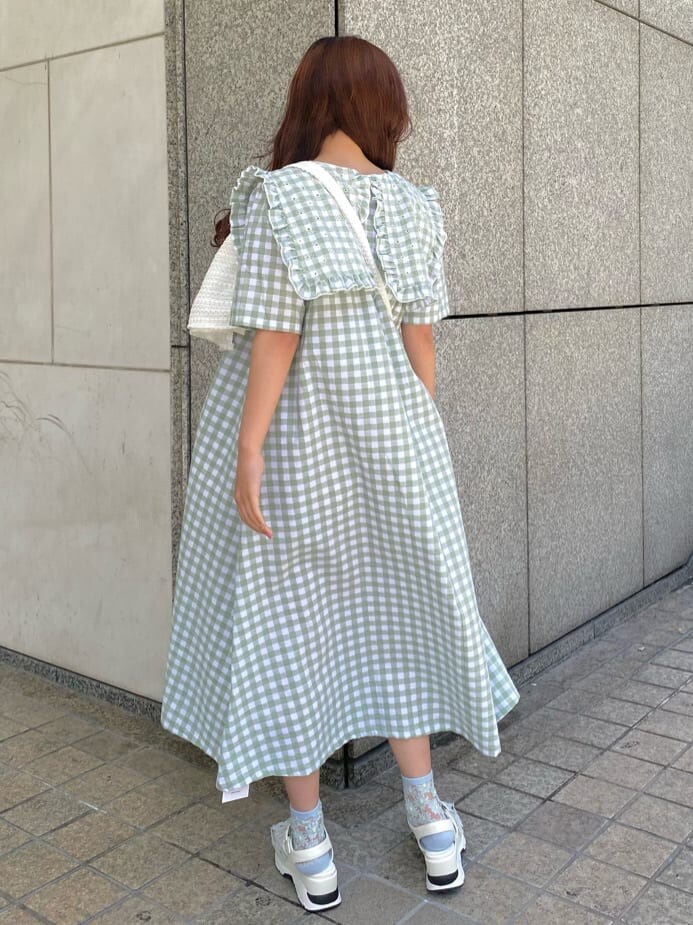 ホワイト系のサンダル、ホワイト系のショルダーバッグ、グリーン系のワンピースを着用したレディースの春コーディネートの3枚目の写真