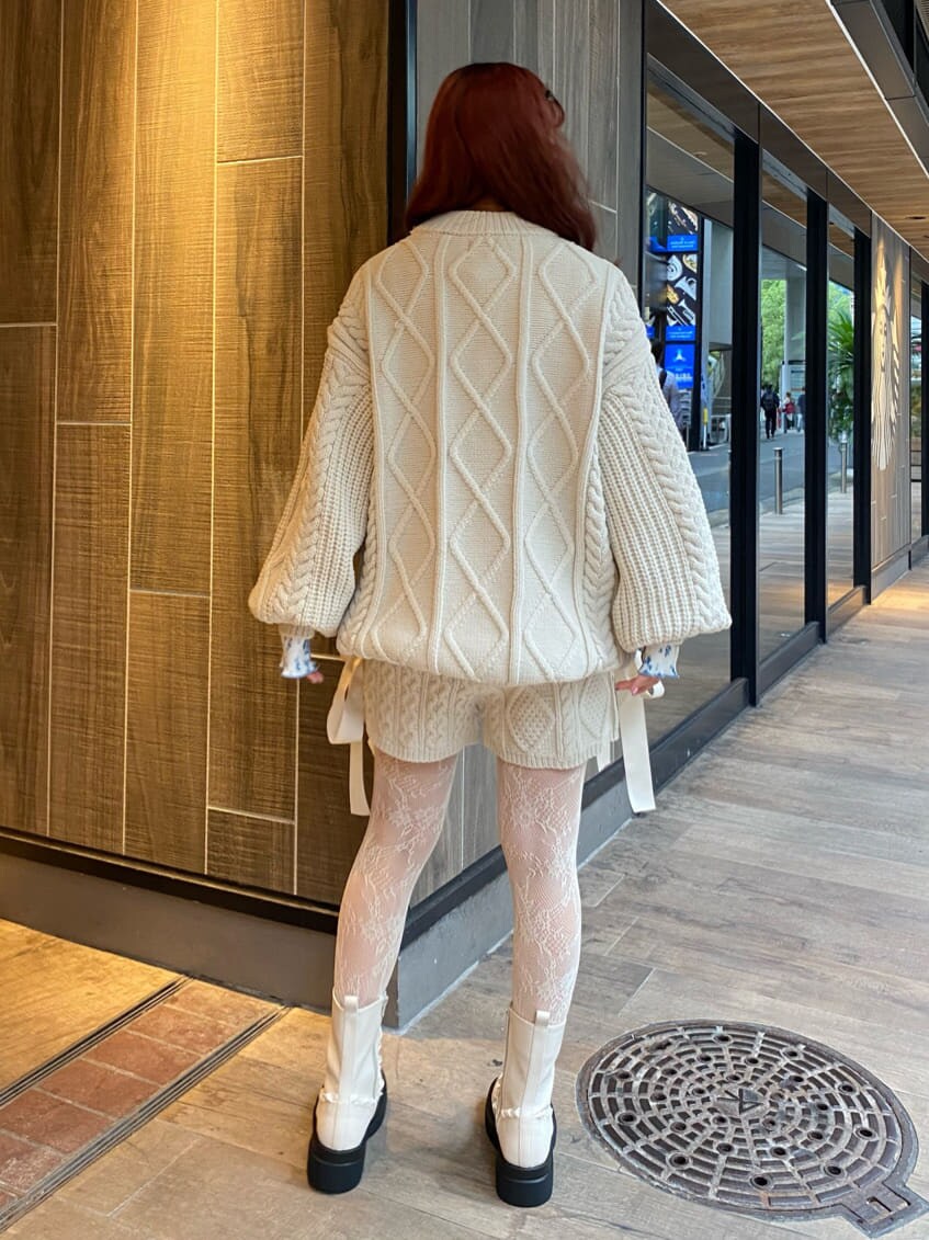 ホワイト系のニット/セーター、ホワイト系のブーツ、ブルー系のチュニックを着用したレディースの秋コーディネートの3枚目の写真