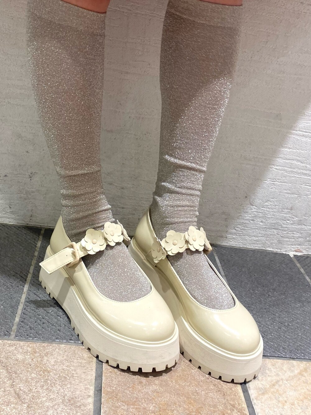 ピンク系のステンカラーコート、ホワイト系のローファー、ホワイト系のニットキャップ/ビーニーを着用したレディースの冬コーディネートの6枚目の写真