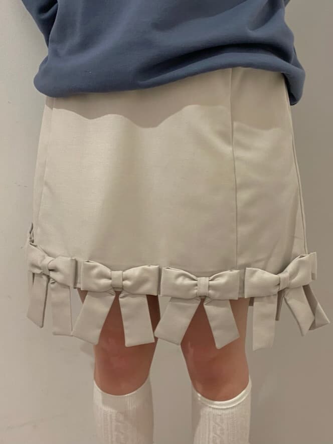 ホワイト系のシャツ/ブラウス、ベージュ系のスカート、ホワイト系のスニーカーを着用したレディースの冬コーディネートの4枚目の写真