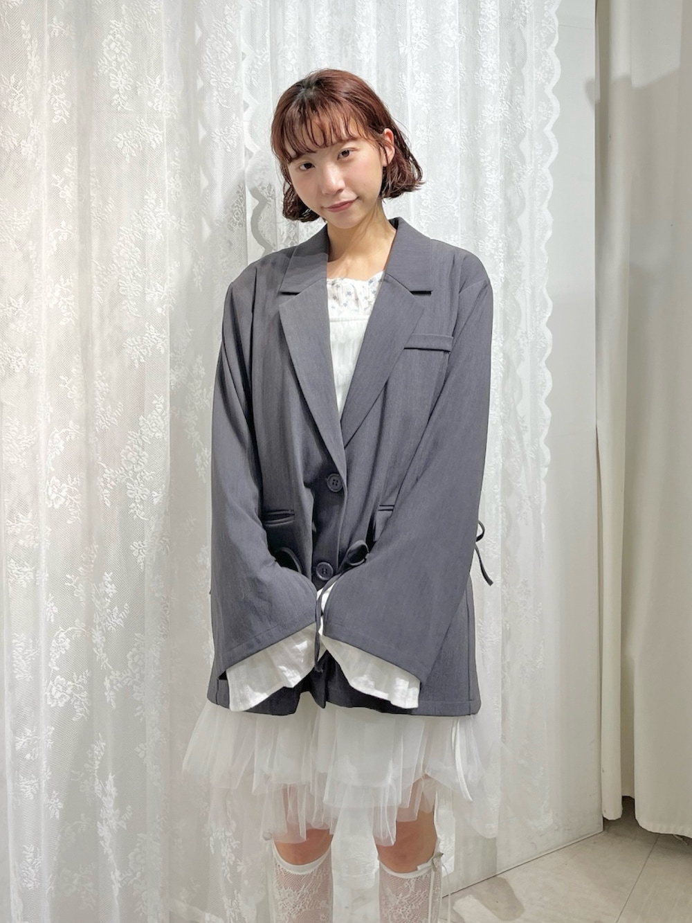 グレー系のテーラードジャケット、ブルー系のTシャツ/カットソー、ホワイト系のワンピースを着用したレディースの冬コーディネートの6枚目の写真
