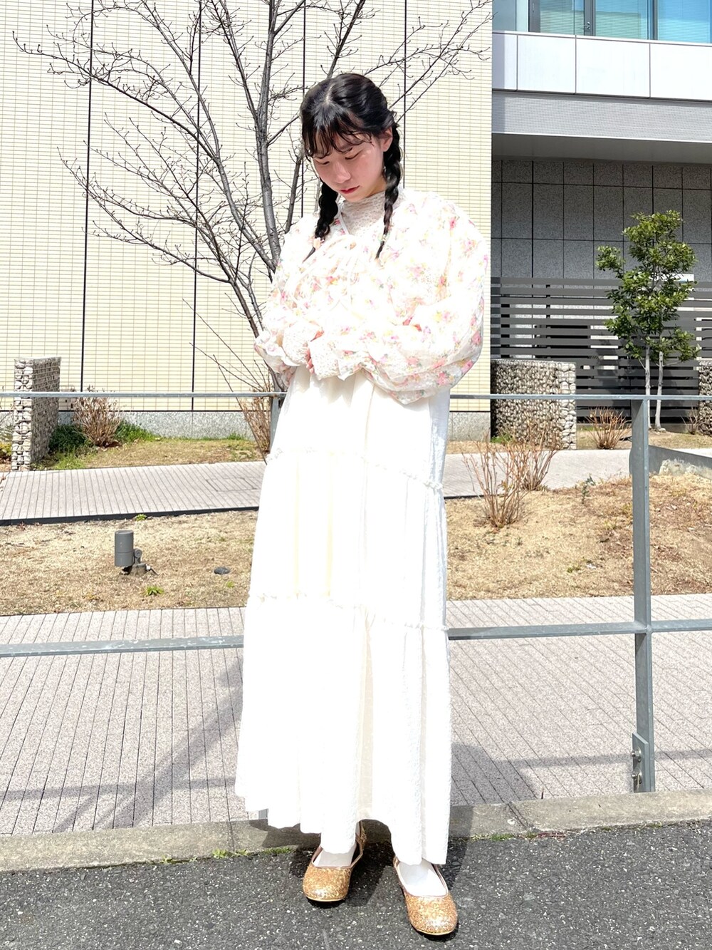 ホワイト系のカーディガン/ボレロ、ホワイト系のワンピース、ゴールド系のパンプスを着用したレディースの春コーディネートの2枚目の写真