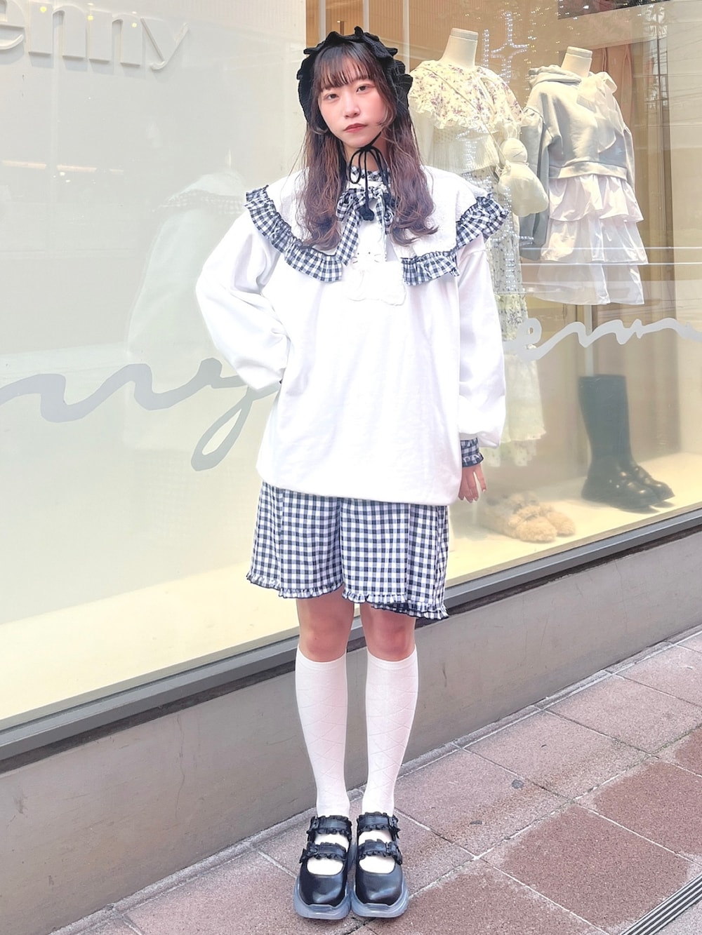 ホワイト系のスウェット、ブラック系のワンピース、ブラック系のスニーカーを着用したレディースの冬コーディネートの3枚目の写真