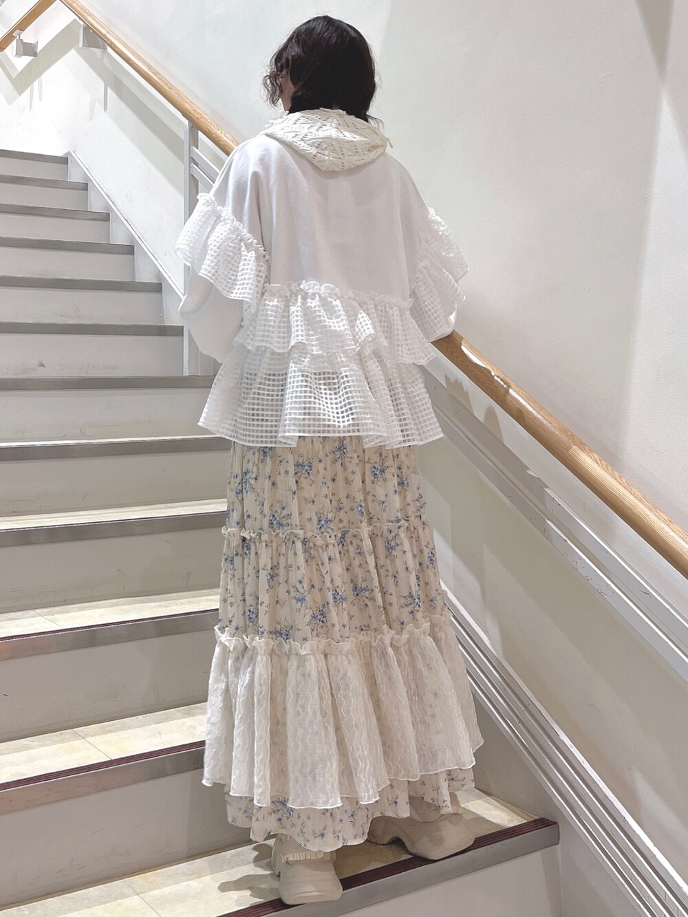 ホワイト系のスウェット、ブルー系のスカート、ホワイト系のスニーカーを着用したレディースの冬コーディネートの4枚目の写真