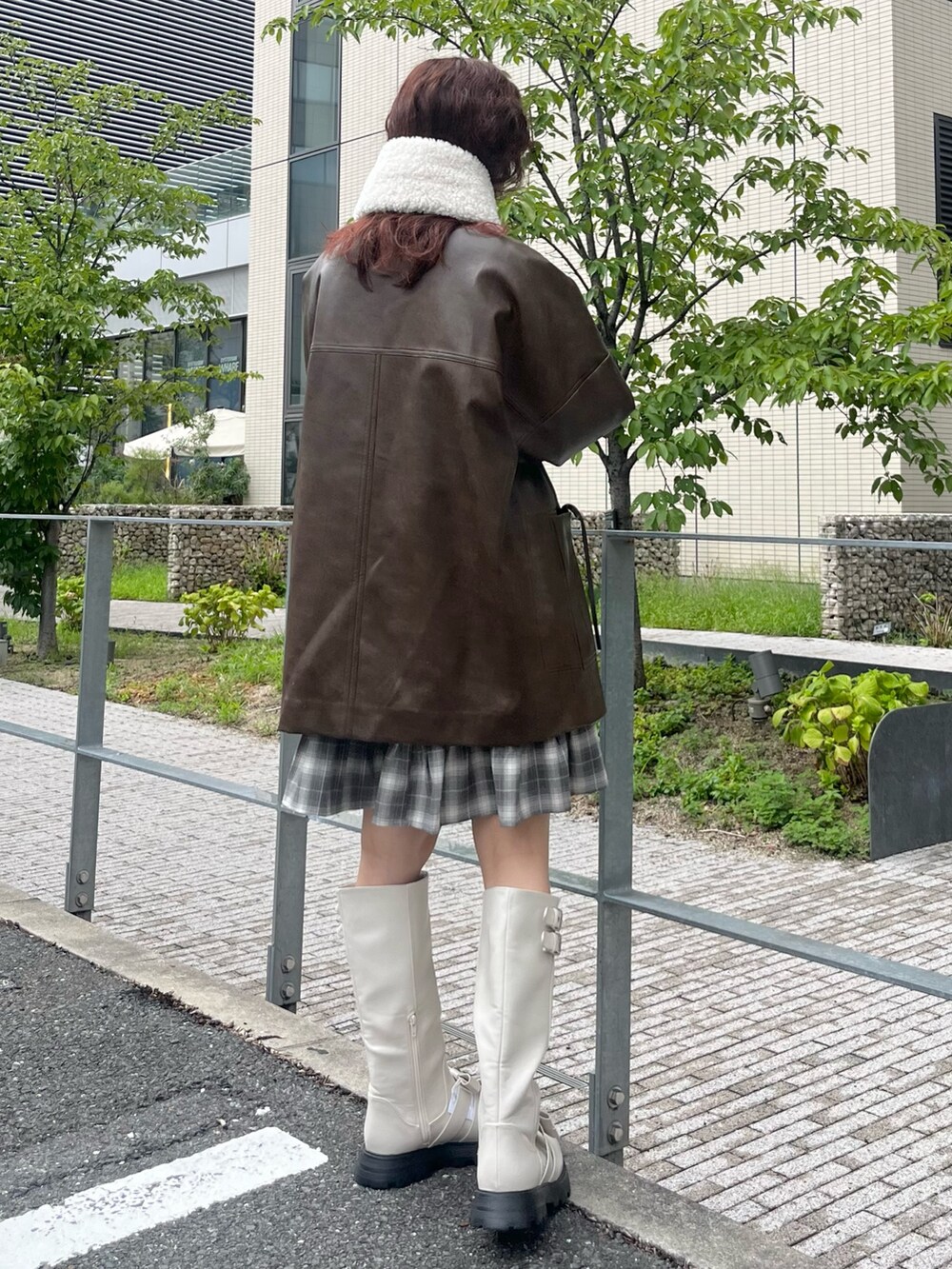 グレー系のワンピース、ホワイト系のブーツ、ブラウン系のブルゾンを着用したレディースの夏コーディネートの3枚目の写真