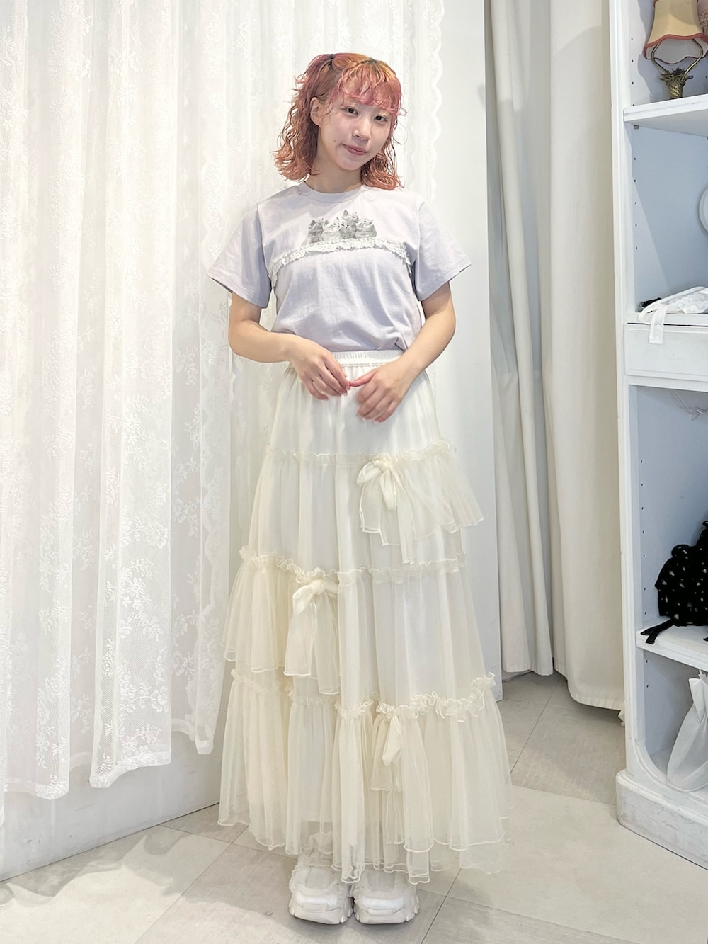 ブルー系のTシャツ/カットソー、ホワイト系のスカート、ホワイト系のスニーカーを着用したレディースの春コーディネートの2枚目の写真