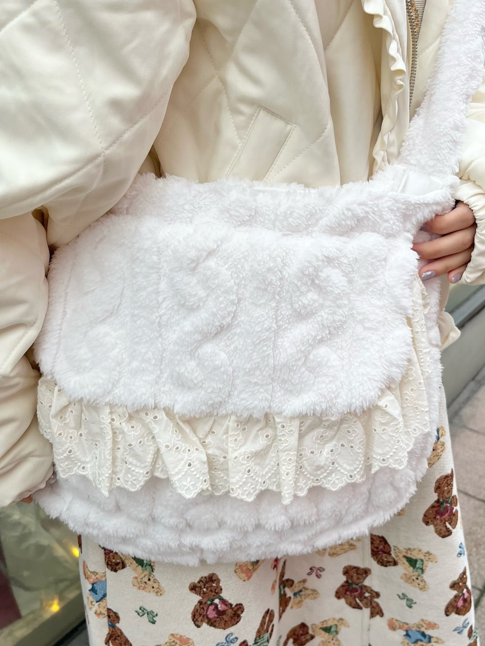 ホワイト系のダウンジャケット/コート、ホワイト系のショルダーバッグ、ホワイト系のニット/セーターを着用したレディースの冬コーディネートの9枚目の写真