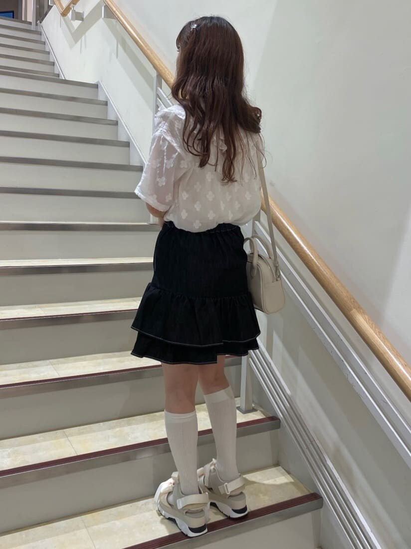 ブラック系のスカート、ホワイト系のサンダル、ホワイト系のショルダーバッグを着用したレディースの春コーディネートの4枚目の写真